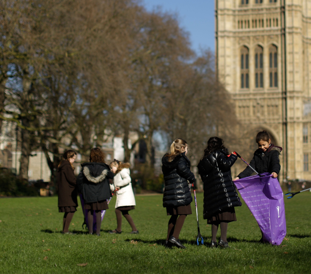 Pupils from the Channing School for girls look for litter in Victoria Tower Gardens, next to the Houses of Parliament in London, during the “Clean for the Queen” campaign Friday.