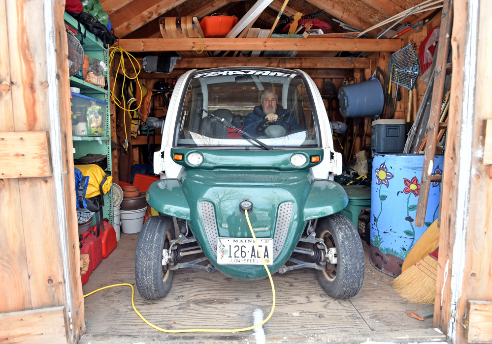 High school art teacher Iver Lofving sits in his electric car stowed in his shed at his home in Skowhegan.