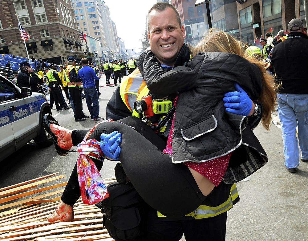 Boston Firefighter James Plourde carries Victoria McGrath from the scene after a bombing near the Boston Marathon finish line in this April 15, 2013 file photo. McGrath, originally from Westport, Conn., and another student were killed in a car accident in Dubai over the weekend while on a personal trip.