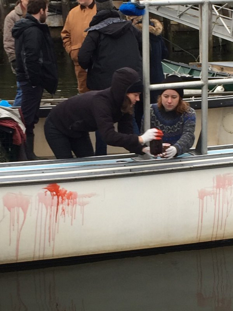 Crew members of the horror film “Island Zero” apply fake blood to a lobster boat in Camden Harbor last week.