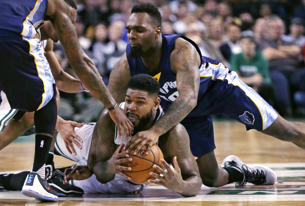The Associated Press Amir Johnson of the Celtics, bottom, grabs a loose ball as Memphis forward P.J. Hairston, right, tries to knock it free during the second quarter Wednesday night in Boston.