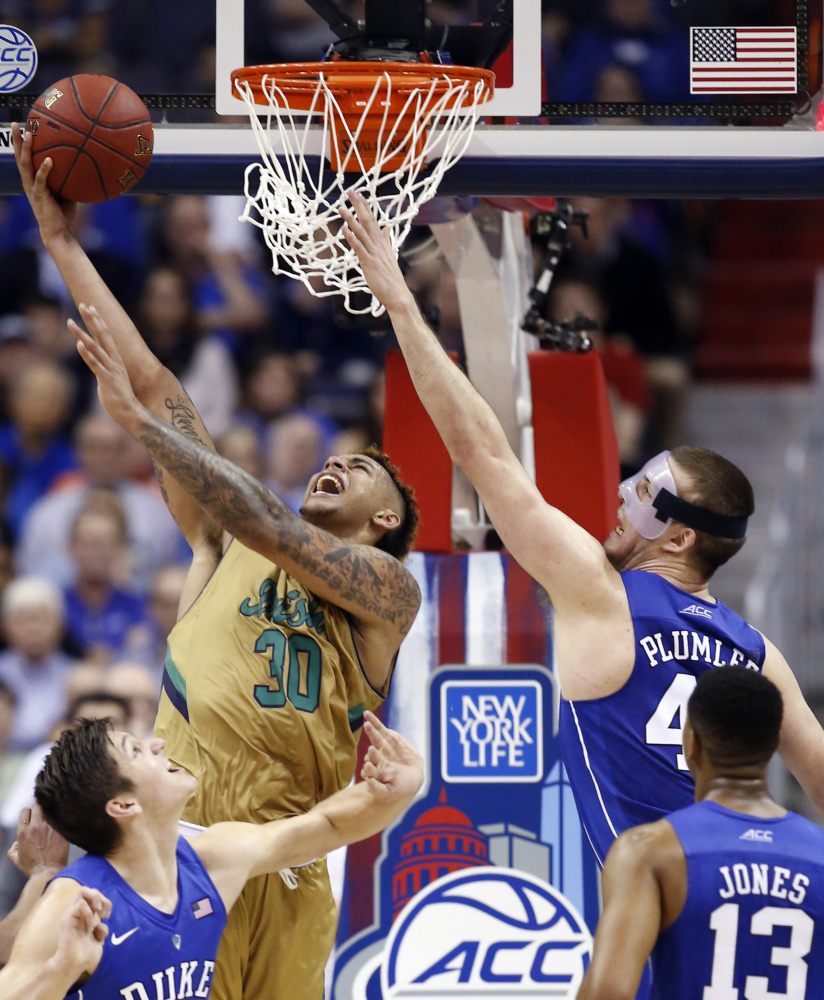 Notre Dame forward Zach Auguste rises from a sea of Blue Devils to score during the second half of Thursday’s 84-79 victory over Duke in the ACC tournament.