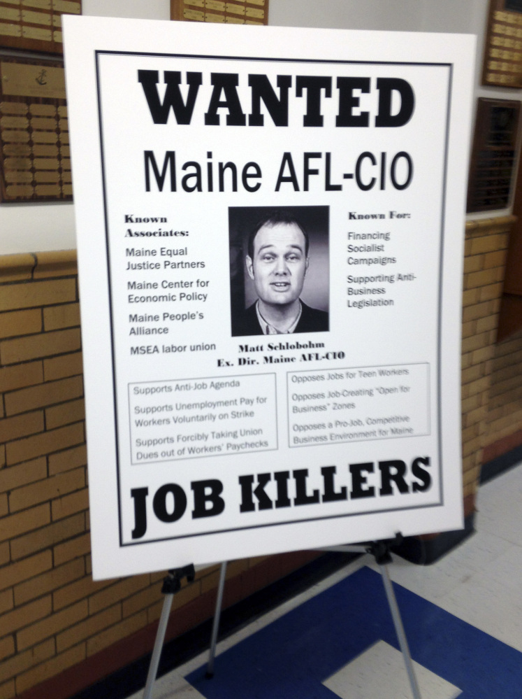 One of three wanted posters that drew criticism of Maine Gov. Paul LePage rests on a stand at the governor's town hall forum in Bath on Thursday. The posters, put up by LePage's staff, targeted the Natural Resources Council of Maine, Maine People's Alliance and Maine AFL-CIO.