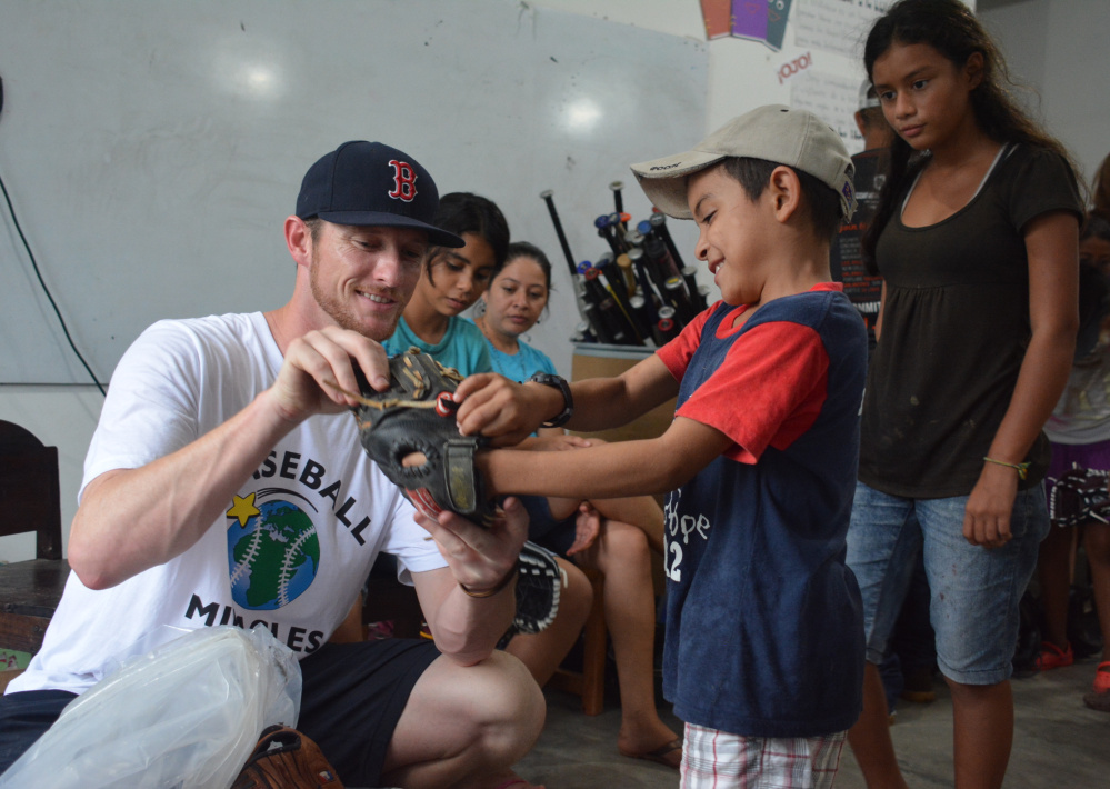 Michael McCarthy gives a young boy his first glove while on a January visit to Honduras. All of the equipment is donated, with McCarthy leading an annual equipment drive with the Portland Sea Dogs at Hadlock Field.