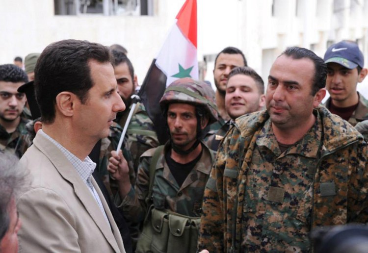 Syrian President Bashar Assad, left, talks to government soldiers during his visit to the Christian village of Maaloula, near Damascus, last April.