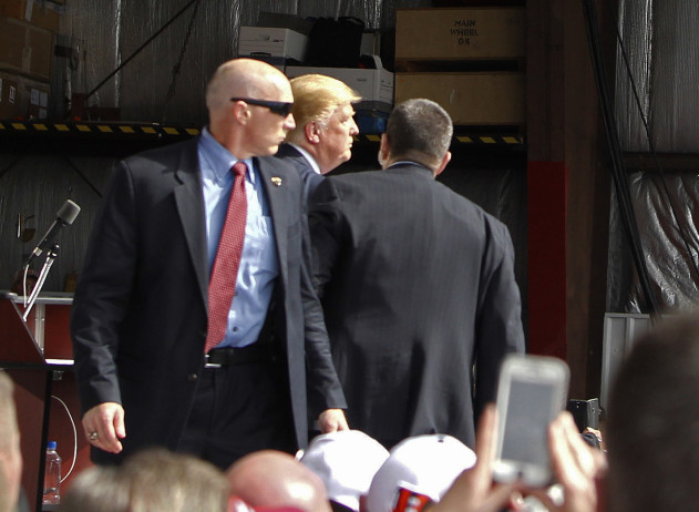 Secret Service agents guard Republican presidential candidate, businessman Donald Trump, on the stage after a man tried to breach the security buffer at his campaign event at the Wright Brothers Aero Hangar Saturday, in Vandalia, Ohio.