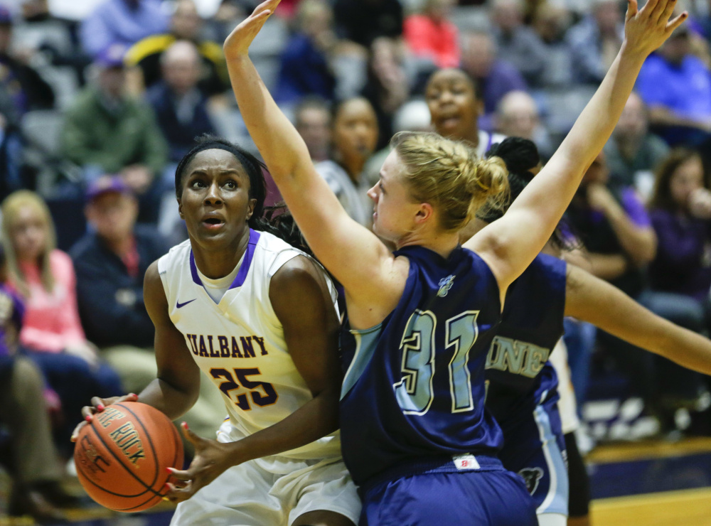 Albany forward Shereesha Richards drives on Maine forward Liz Wood during the second half Friday, in Albany, N.Y. Albany won 59-58. The Associated Press