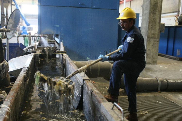 Ameen Uddin removes trash that has been separated from incoming wastewater at the Hyperion sewage treatment plant in 2012 in Los Angeles. Tribune News Service photo