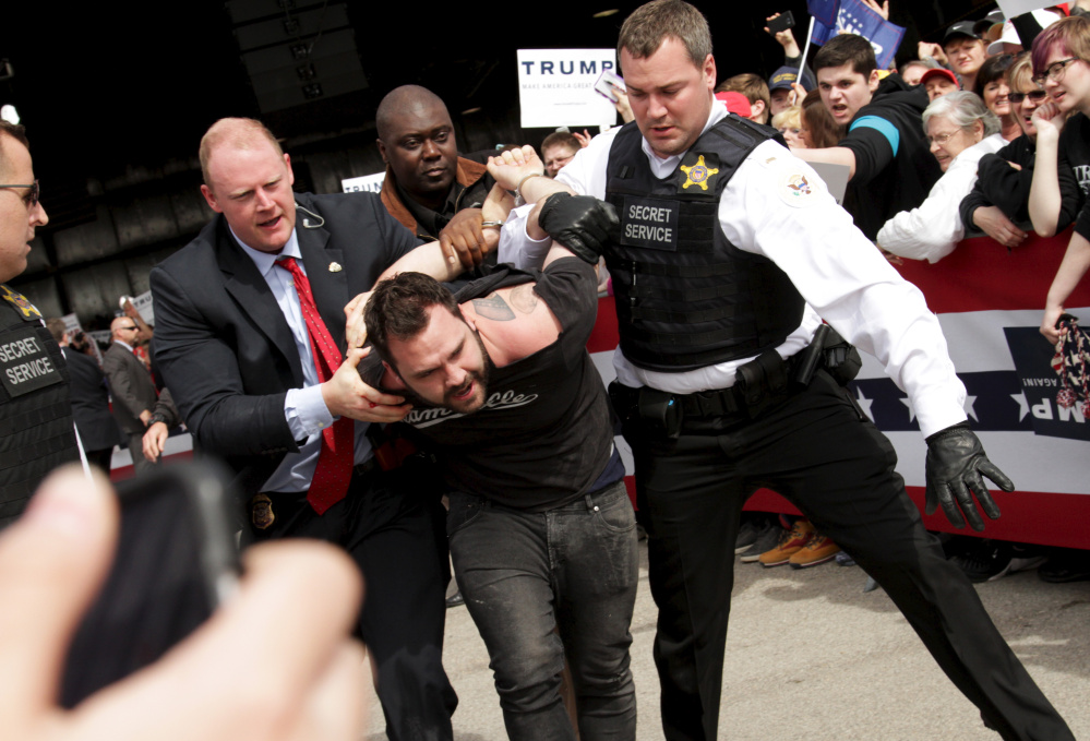 Secret Service agents detain a man after a disturbance at Donald Trump’s rally Saturday in Dayton, Ohio, where he figures to outpoll popular Gov. John Kasich.