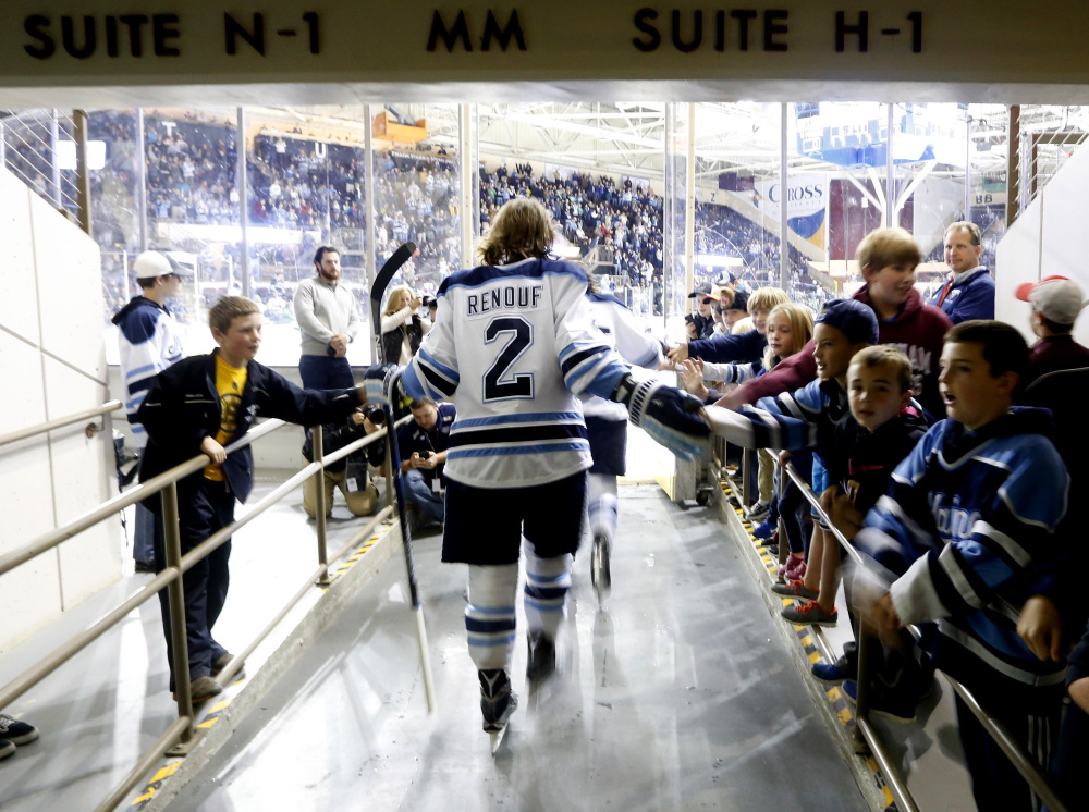 University of Maine defenseman Dan Renouf gets some good vibes from young fans before a game against North Dakota during the Ice Breaker tournament at Cross Insurance Arena last fall. Despite the team’s recent struggles, UMaine finds plenty of support.