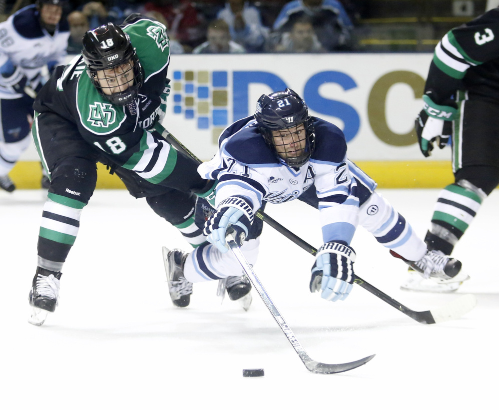 UMaine’s Cam Brown reaches for the puck in a game against North Dakota last fall. The team ended its season last weekend with an 8-24-6 record, the second worst in Black Bear history.