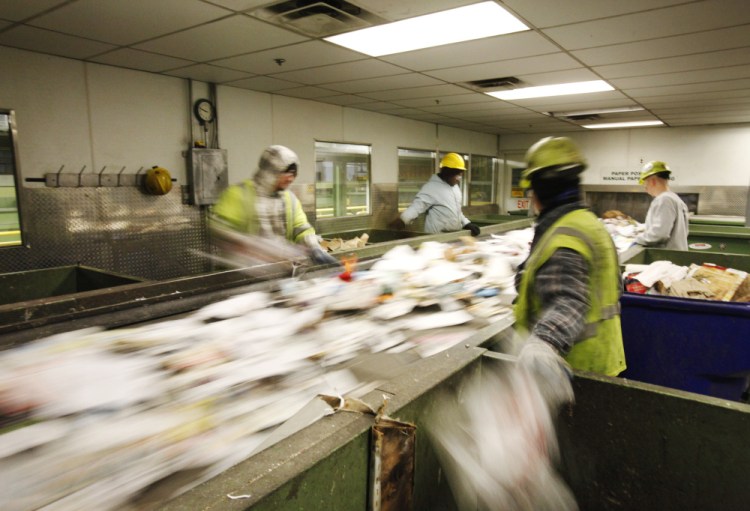 Sorters separate recyclable materials recently at ecomaine’s recycling facility in Portland. 