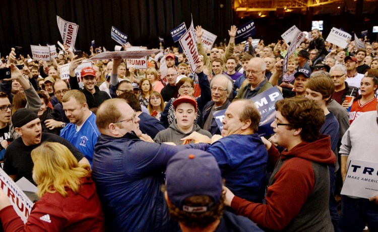 A protester, center left, and a Trump supporter, center right, scuffle during a rally for Republican presidential candidate Donald Trump Saturday held at the I-X Arena in Cleveland, Ohio.