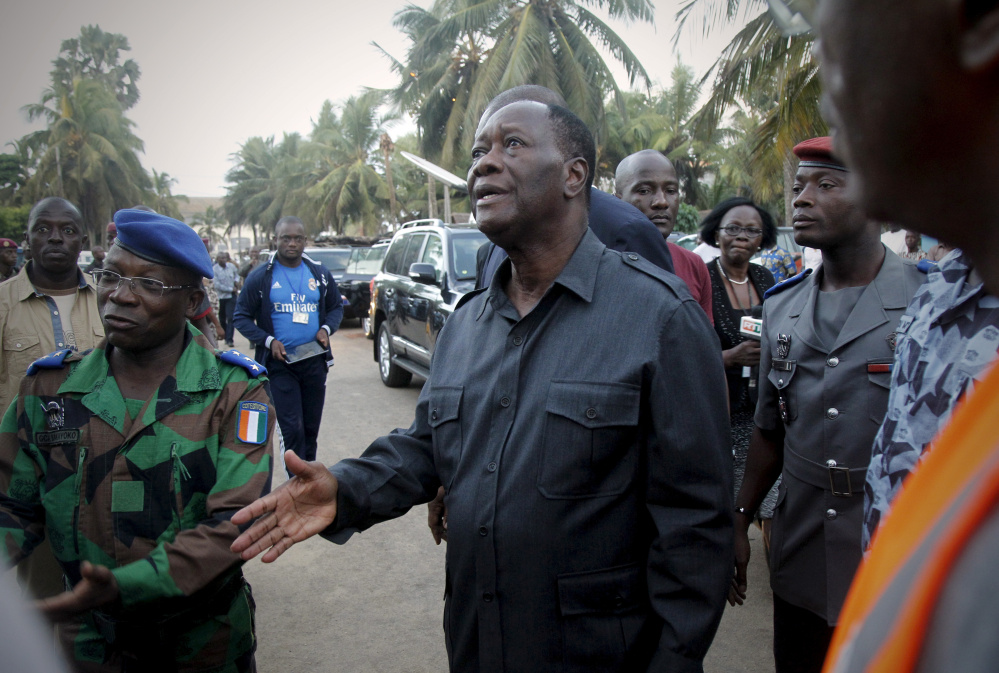 Ivory Coast President Alassane Ouattara, center, arrives at the hotel Etoile du Sud in Grand-Bassam a few hours after gunmen terrorized beachgoers on Sunday.
