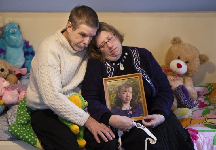 Robert and Susan Meehan sit on the bed of their daughter Cyndimae and hold her photo on Monday. Cyndimae, who moved to Maine with her family in 2013 so that her seizure condition could be legally treated with medical cannabis, died unexpectedly Sunday in her father’s arms.