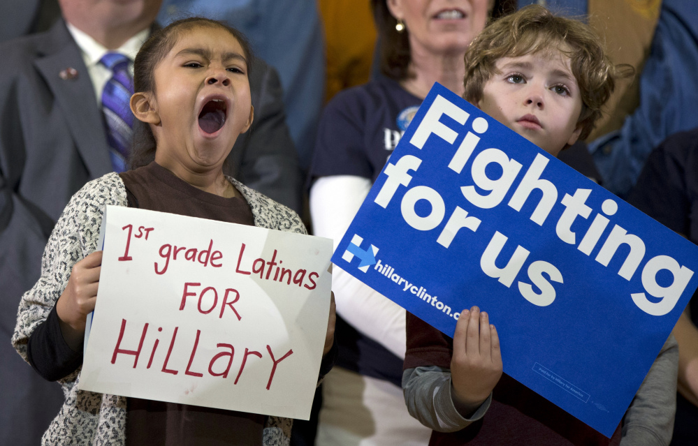A little girl yawns as she holds her sign on stage behind Democratic presidential candidate Hillary Clinton during a campaign event at Chicago Journeymen Local Plumbers Union in Chicago on Monday. The Associated  Press 