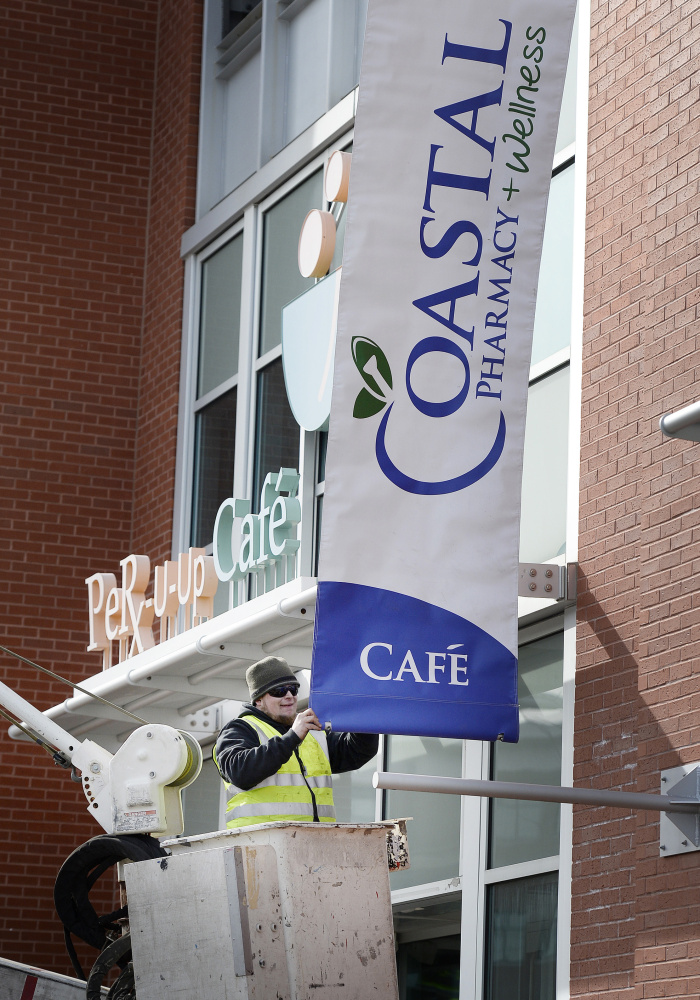 PORTLAND, ME - MARCH 1: Tyler Campbell of Bailey Signs puts up a sign at Coastal Pharmacy and Wellness, formerly Apothecary Design in Portland Tuesday, March 1, 2016. (Photo by Shawn Patrick Ouellette/Staff Photographer)