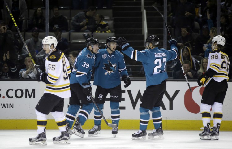 The Sharks’ Melker Karlsson, center, celebrates his goal with teammates Joonas Donskoi (27) and Logan Couture (39) in the first period of Tuesday night’s game in San Jose, Calif. Donskoi scored the game winner in the third period.