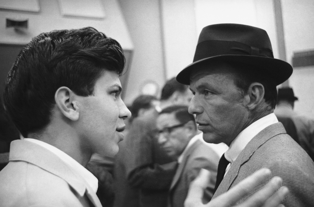 Frank Sinatra Jr. talks with his father in 1962. He had a contentious relationship with the famed singer, but was never far from his father’s orbit in the entertainment world.