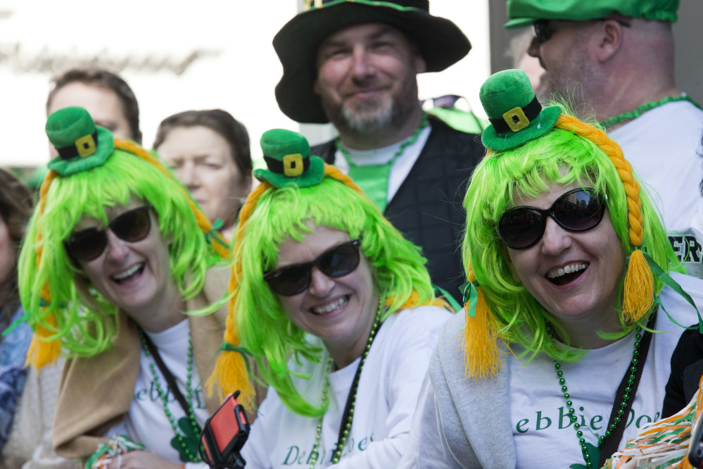 Debbie McDonald, left, Lynn Merrit, center, Elaine Lennan, right and Andrew Lennan, background, all of South Hampton, England, watch the St. Patrick’s Day Parade in New York.