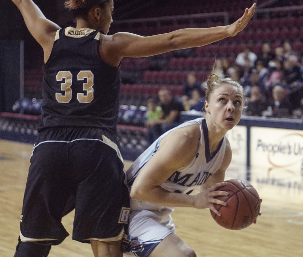 UMaine’s Liz Wood spins around Breanna Rucker of Bryant University during a Dec. 12 game in Bangor. Wood’s scoring is down to single figures, but she’s added assists and playing great defense.