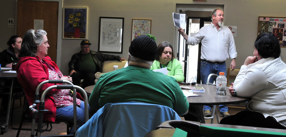 Troy Henderson holds documents while explaining to members of the Waterville Social Club on Thursday that the peer-support center for people recovering from mental illness might be forced to close.