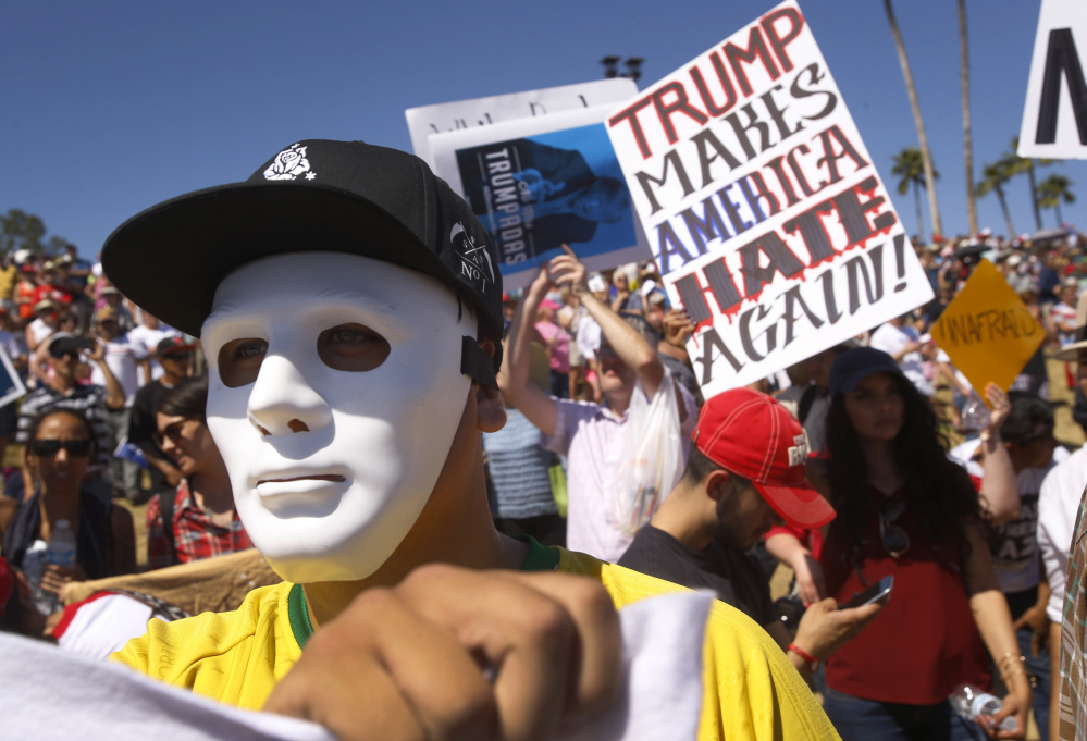 Protesters against Republican presidential candidate Donald Trump appear at a rally for Trump in Fountain Hills, Ariz., on Saturday.