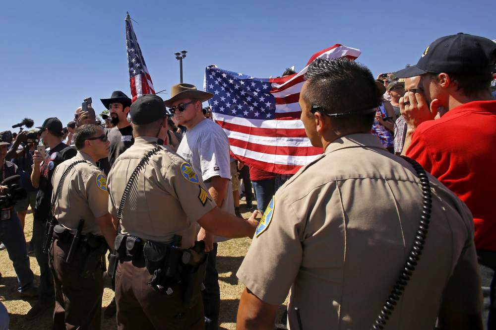 Sheriff’s deputies form a barrier between supporters and protesters that came to see Republican presidential candidate Donald Trump in Fountain Hills, Ariz., on Saturday.