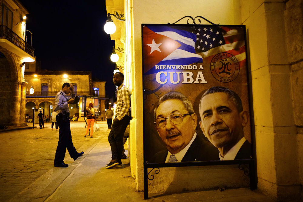 In Havana, a welcome poster features images of Cuba’s President Raul Castro and President Obama, as Obama becomes the first sitting U.S. president to visit in 90 years.