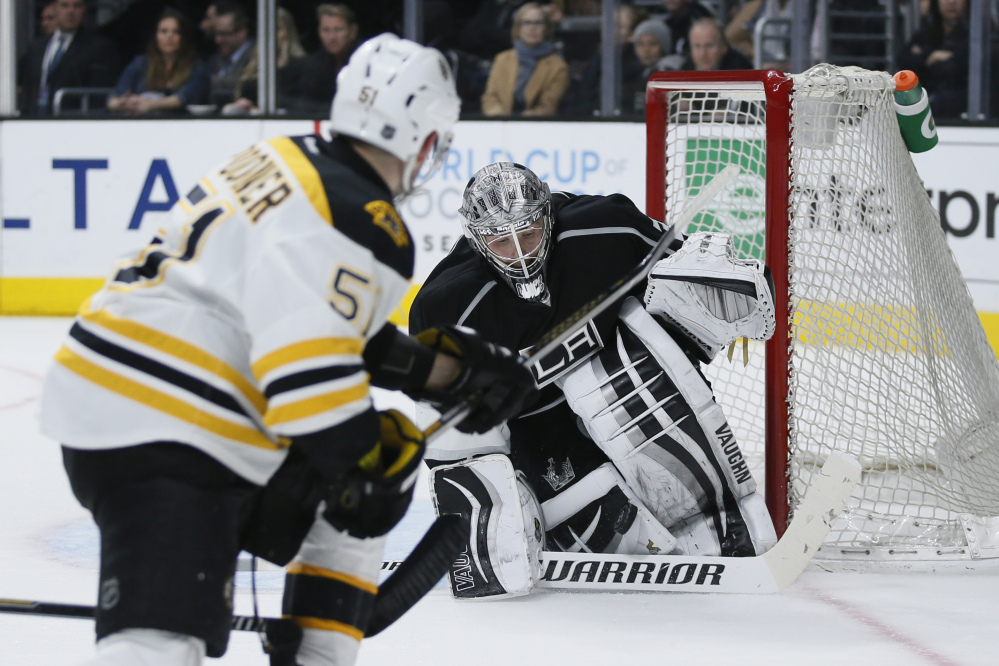 Los Angeles Kings goalie Jonathan Quick, right, makes a save on a shot by Boston Bruins center Ryan Spooner, left, during the third period Saturday in Los Angeles.