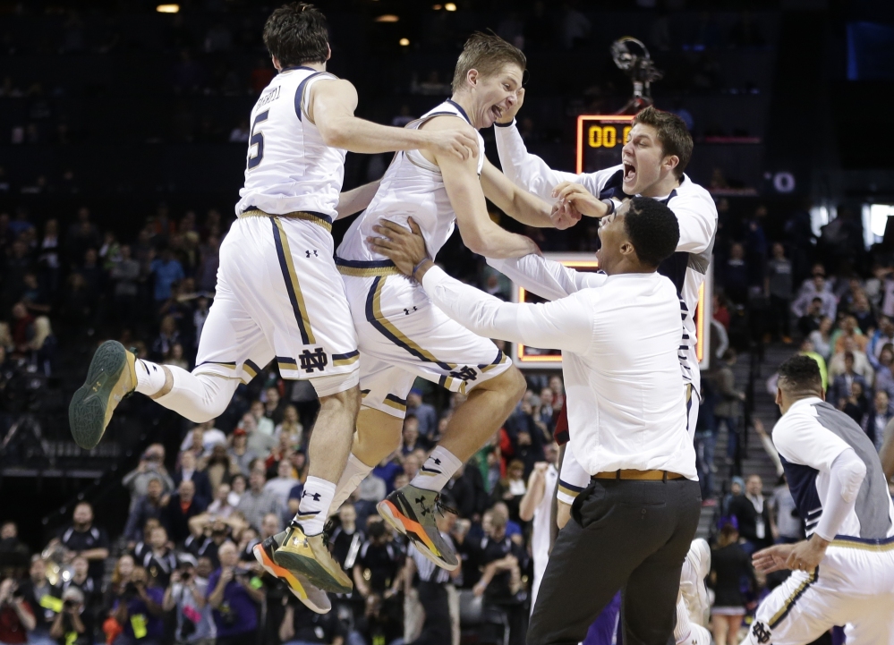 Notre Dame's Rex Pflueger, center, and Matt Farrell, left, celebrate with teammates after a second-round game in the NCAA Tournament on Sunday in New York. Notre Dame won 76-75. 