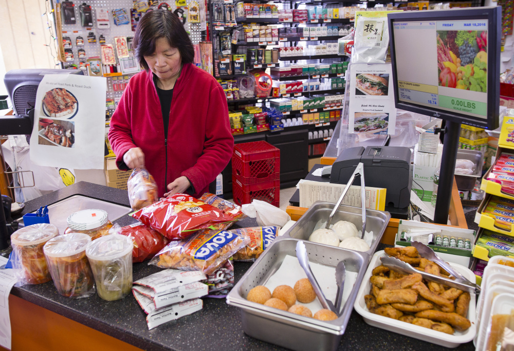 Cashier Mei Lam rings up a customer's purchase at Veranda Asian Market on Forest Avenue in Portland. 