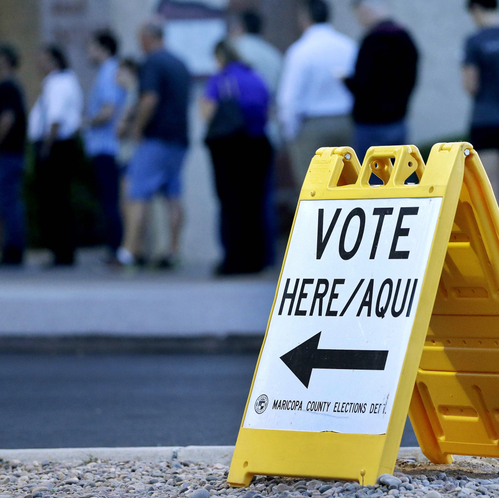 Voters wait to cast ballots in Arizona’s presidential primary Tuesday in Phoenix.