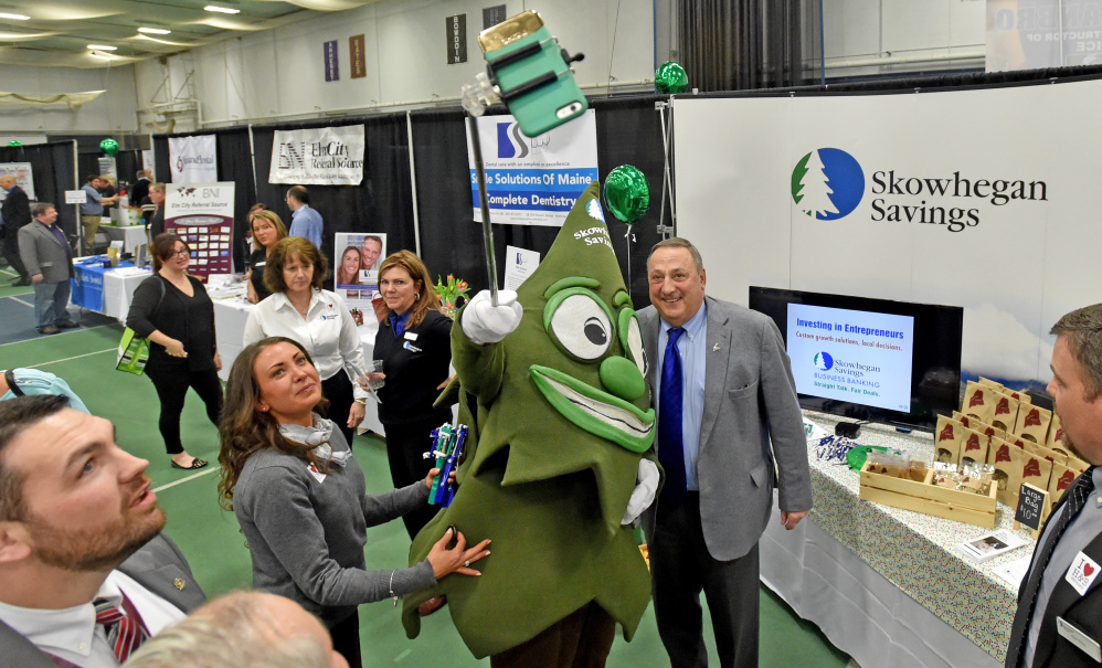 Gov. Paul LePage has a selfie taken Thursday with Trusty, the Skowhegan Savings Bank mascot, and Fawn Wentworth at the 2016 Business-to-Business Showcase at Colby College in Waterville.