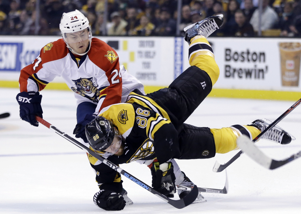 Bruins defenseman Kevan Miller is upended as he chases the puck against Panthers left wing Jiri Hudler in the second period of Thursday night’s loss to Florida.