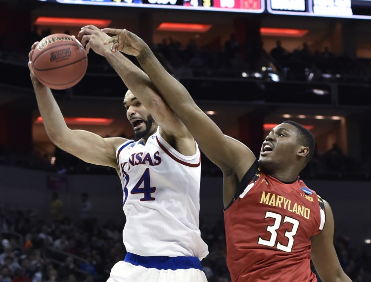 Kansas forward Perry Ellis pulls a rebound away from Maryland center Diamond Stone in the first half of Thursday night’s regional semifinal game in Louisville, Ky. Ellis scored 27 points to lead Kansas.