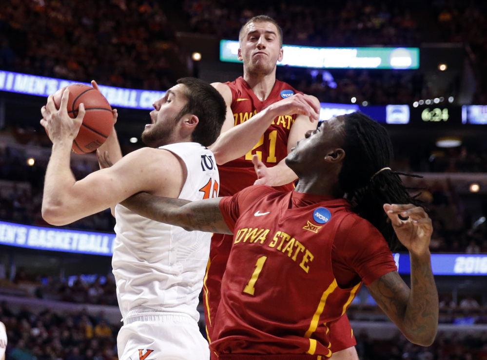 Virginia’s Mike Tobey, 10, grabs a rebound against Iowa State’s Jameel McKay, 1 and Matt Thomas in the first half Friday night in Chicago.