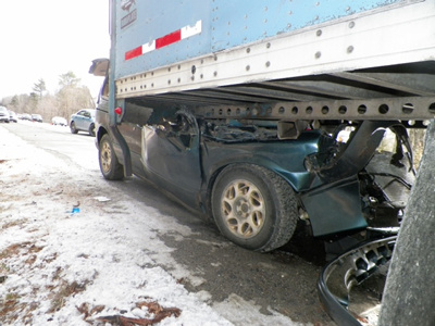 A 1998 Mercury Villager remains wedged under a tractor-trailer Saturday on Interstate 95 in Fairfield after it hit the back end of the paper-loaded rig that morning. The van's  driver, Kenneth Billings, of Bangor, was injured.