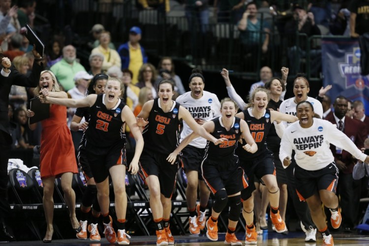 Oregon State players rush the court celebrating their 60-57 win over Baylor in Monday night’s regional final in Dallas. Oregon State is headed to the Final Four for the first time.