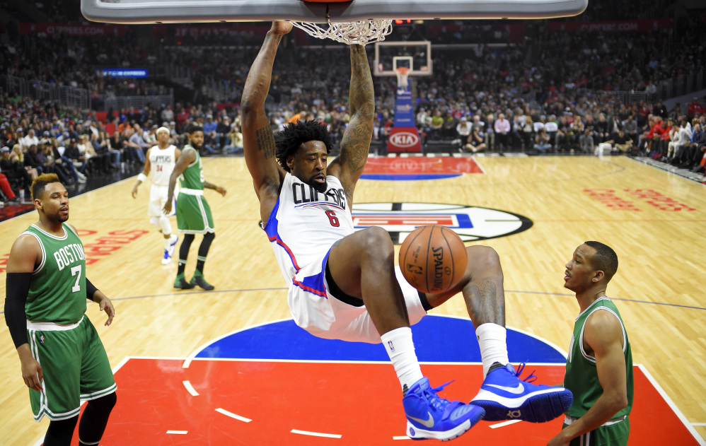 Clippers center DeAndre Jordan dunks as Celtics center Jared Sullinger, left, and guard Avery Bradley can only watch. Jordan finished with 15 points and 13 rebounds in the game.