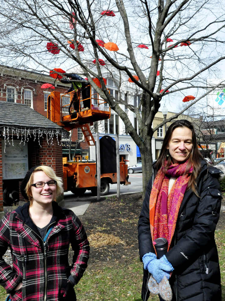 Tamsen Brooke Warner, left, of the Waterville Opera House and Kika Nigals of Waterville Creates!, speak Wednesday about the installation of dozens of umbrellas in a tree downtown Waterville.