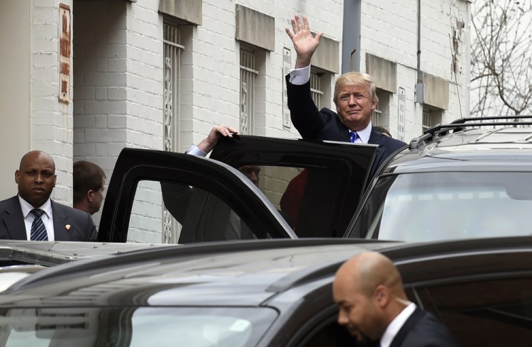 Republican presidential candidate Donald Trump waves as he gets into his vehicle in Washington on Thursday following a meeting at the Republican National Committee headquarters.