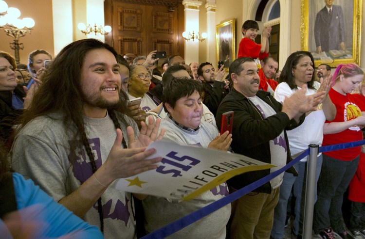 Supporters of a bill to raise California's minimum wage to $15 an hour celebrate outside the state Senate Chamber after the measure was approved by the Senate on Thursday.