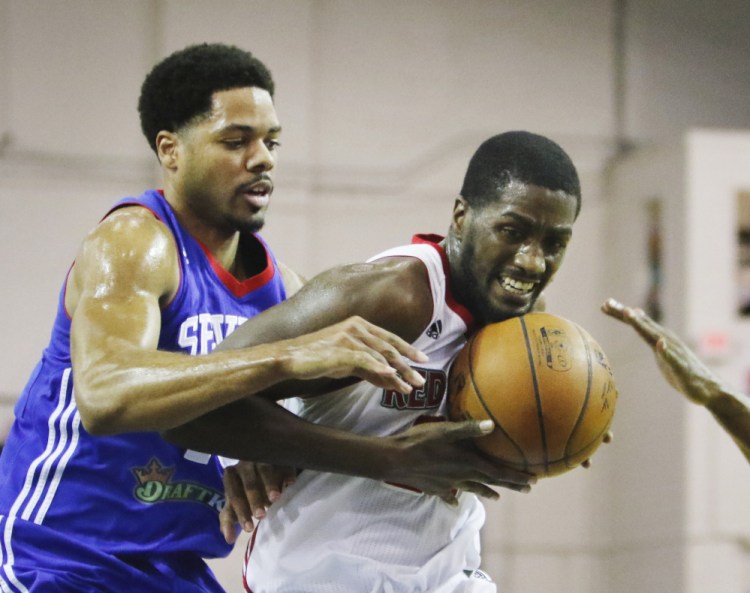 Omari Johnson of the Maine Red Claws protects the ball against Rodney Carney of the Delaware 87ers during the first half action Thursday at the Portland Expo.