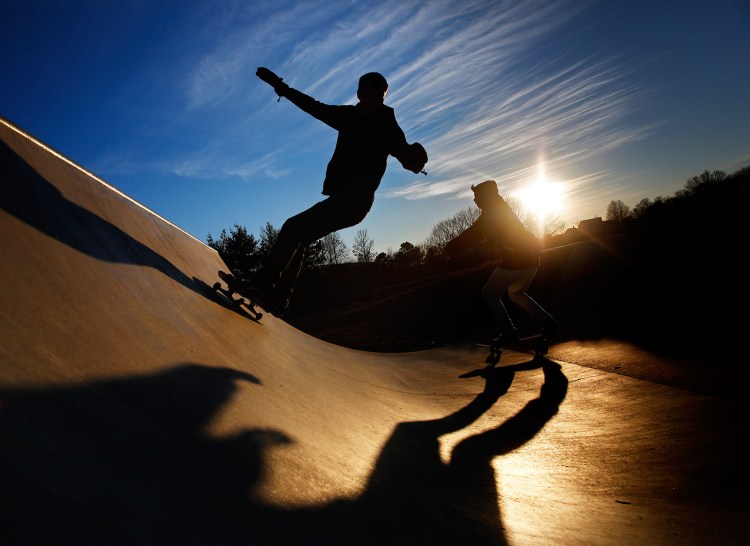 Calvin Shimko, 17, left, and Niko Torres, 17, both of Naples, cast long shadows while riding their skateboards at Dougherty Field in Portland in March. City officials hope to ease overcrowding at the park by doubling its size.