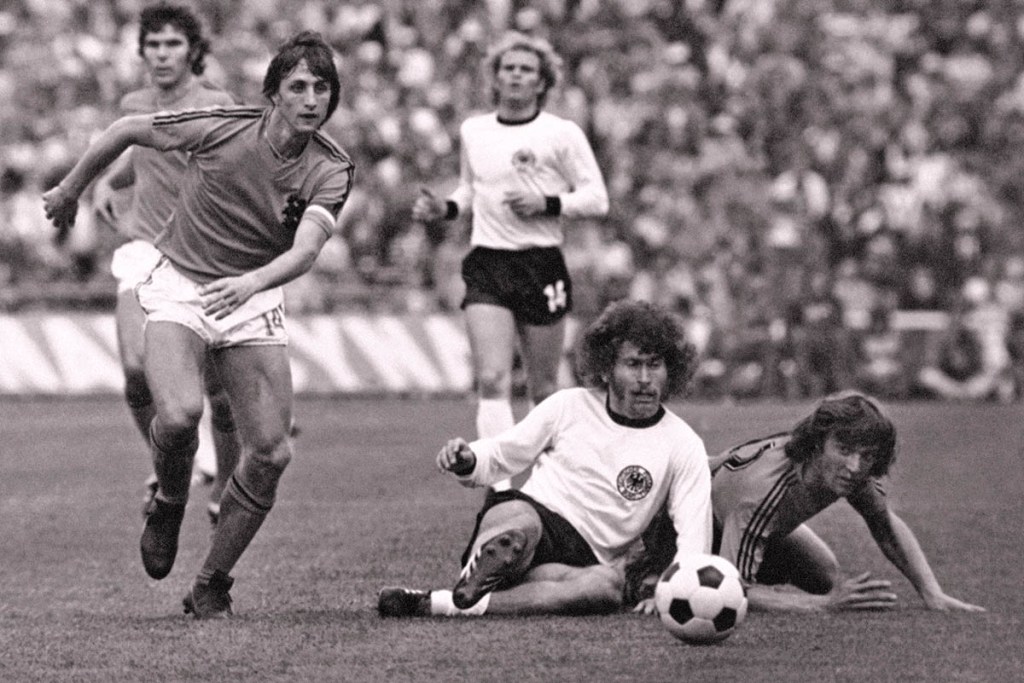 Dutch forward Johan Cruyff, left, runs past German defender Paul Breitner, sitting on the pitch, during the final of the Soccer World Cup at the Olympic Stadium in Munich, Germany, in this July 7, 1974, photo. Cruyff revolutionized the game with the concept of "Total Football." The Associated Press
