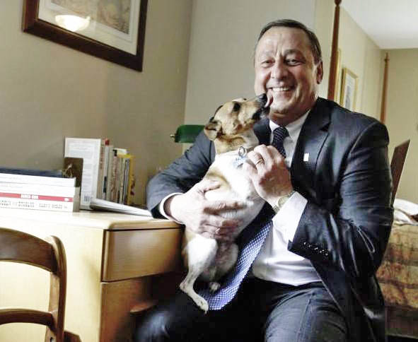 Gov. Paul LePage gets a dog kiss from Baxter, the family's Jack Russell terrier mix that died Tuesday.
