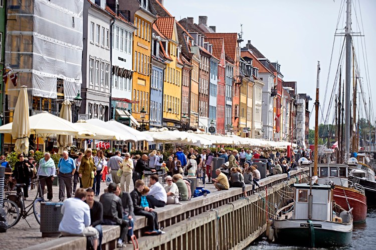 Visitors crowd Nyhan, a 17th-century canal and entertainment district in Copenhagen. In a study of 156 countries, the U.N. has determined Danes to be the happiest people on Earth. The Associated Press