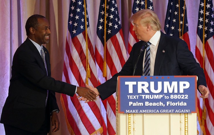 Former Republican presidential candidate Ben Carson and Donald Trump shake hands on March 11, 2016, after Carson announced he would endorse Trump for president.