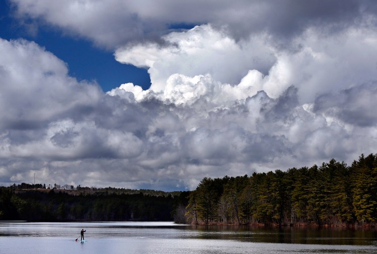 Storm clouds build before a thunderstorm as Jeff Warren of Auburn heads for shore on his paddleboard on Lower Range Pond on Thursday in Poland. Plenty of rain has offset the lack of snowmelt this spring in the Northeast.